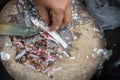 A woman is cutting the belly the fish and taking away the intestines,  Which may have parasites in it, than washing by clean water Royalty Free Stock Photo