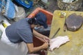 A woman is cutting chicken meat to sell in her stall