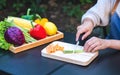 A woman cutting and chopping asparagus and carrot by knife on wooden board Royalty Free Stock Photo