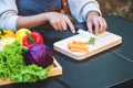 A woman cutting and chopping asparagus and carrot by knife on wooden board Royalty Free Stock Photo