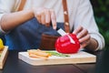 A woman cutting and chopping red bell pepers by knife on wooden board with mixed vegetables in a tray Royalty Free Stock Photo