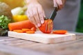 A woman cutting and chopping tomato by knife on wooden board Royalty Free Stock Photo