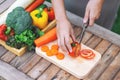 A woman cutting and chopping tomato by knife on wooden board Royalty Free Stock Photo