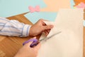 Woman cutting color paper with scissors at wooden table, closeup Royalty Free Stock Photo