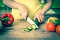 Woman cutting cucumber for salad - retro style Royalty Free Stock Photo