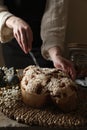 Woman cutting delicious Italian Easter dove cake (traditional Colomba di Pasqua) at wooden table, closeup