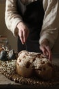 Woman cutting delicious Italian Easter dove cake (traditional Colomba di Pasqua) at wooden table, closeup