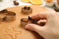 Woman cutting dough with cookie cutter at table, closeup. Christmas biscuits Royalty Free Stock Photo