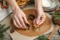 Woman cutting dough with cookie cutter at wooden table, closeup. Christmas biscuits Royalty Free Stock Photo