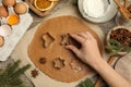 Woman cutting dough with cookie cutter at wooden table, top view. Christmas biscuits Royalty Free Stock Photo