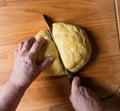 Woman cutting dough into pieces for further rolling Royalty Free Stock Photo