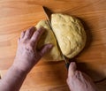 Woman cutting dough into pieces for further rolling Royalty Free Stock Photo