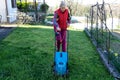 A woman cutting down grass with mow