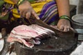 Woman cutting fish outdoor in Mumbai, India