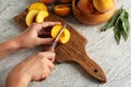 Woman cutting fresh peaches at wooden table Royalty Free Stock Photo