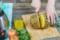 Woman cutting a fresh pineapple on a wooden cutting board Royalty Free Stock Photo