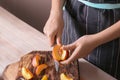 Woman cutting fresh sweet peaches at wooden table, closeup Royalty Free Stock Photo
