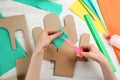 Woman cutting green paper at white wooden table, top view. Pinata DIY Royalty Free Stock Photo