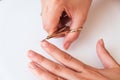 The woman is cutting her nails with small scissors by herself in close up photo on white background. View from above. Manicure at Royalty Free Stock Photo