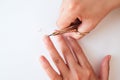 The woman is cutting her nails with small scissors by herself in close up photo on white background. View from above. Manicure at Royalty Free Stock Photo
