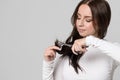 Woman cutting her split ends, holding scissors, isolated.Trim hair, separated dry ends Royalty Free Stock Photo