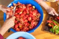 Woman cutting large amount of tomatoes for prepare tomato sauce. Preparation of tomatoes for cooking.