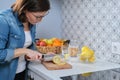 Woman cutting lemon with knife on cutting board in the kitchen Royalty Free Stock Photo