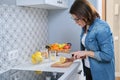 Woman cutting lemon with knife on cutting board in the kitchen Royalty Free Stock Photo