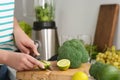 Woman cutting lime for smoothie in kitchen, closeup Royalty Free Stock Photo