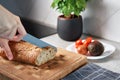 Woman Cutting Loaf Of Bread With Large Knife Royalty Free Stock Photo