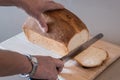 Woman cutting a loaf of white bread Royalty Free Stock Photo
