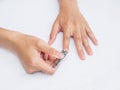 Woman cutting nails using nail clipper on white background. heal Royalty Free Stock Photo