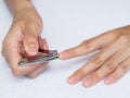 Woman cutting nails using nail clipper on white background. heal Royalty Free Stock Photo