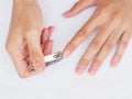 Woman cutting nails using nail clipper on white background. heal Royalty Free Stock Photo