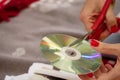 Woman cutting old compact discs with scissors at home close up view Royalty Free Stock Photo