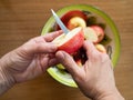 Woman Cutting an Organic Apple with a Tin Bowl with Apples in th Royalty Free Stock Photo