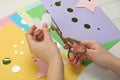 Woman cutting paper heart with scissors at white wooden table, closeup Royalty Free Stock Photo