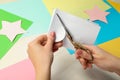 Woman cutting paper with scissors at white wooden table, closeup Royalty Free Stock Photo