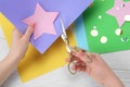 Woman cutting paper star with scissors at white wooden table, top view Royalty Free Stock Photo