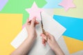 Woman cutting paper star with scissors at white wooden table, top view Royalty Free Stock Photo