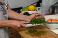 woman cutting parsley on a cutting board in the kitchen 7