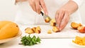 Woman cutting peach. Close up view, white background Royalty Free Stock Photo