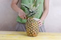 Woman cutting a pineapple over wood. Royalty Free Stock Photo