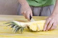 Woman cutting a pineapple over wood. Royalty Free Stock Photo