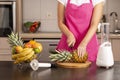 Woman cutting pineapple top with a kitchen knife Royalty Free Stock Photo