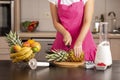 Woman cutting a pineapple top Royalty Free Stock Photo