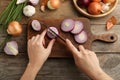 Woman cutting red onion on board at table, top view Royalty Free Stock Photo