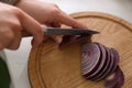 Woman cutting red onion into slices at countertop in kitchen, closeup Royalty Free Stock Photo