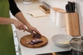 Woman cutting red onion into slices at table in kitchen, closeup Royalty Free Stock Photo