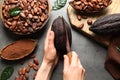 Woman cutting ripe cocoa pod over grey table with products, top Royalty Free Stock Photo